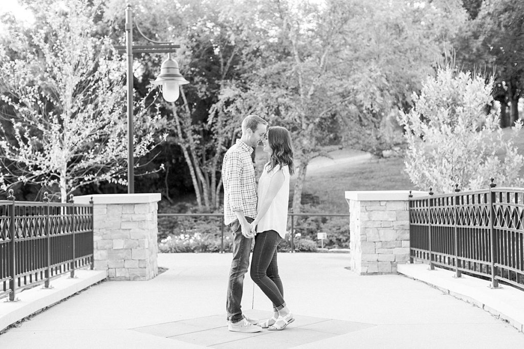 Couple kissing on bridge in black and white
