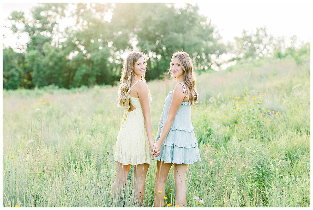 Twins holding hands in a field