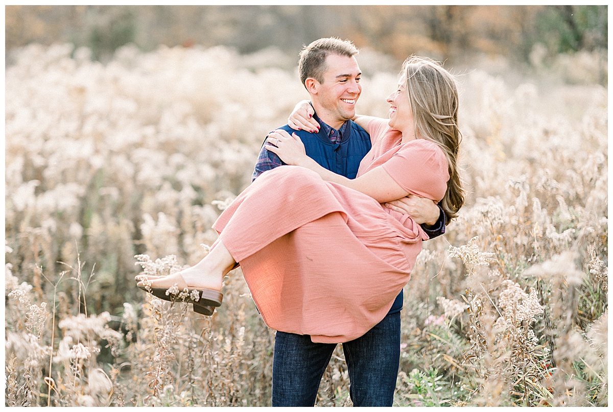 man carrying woman for engagement photos