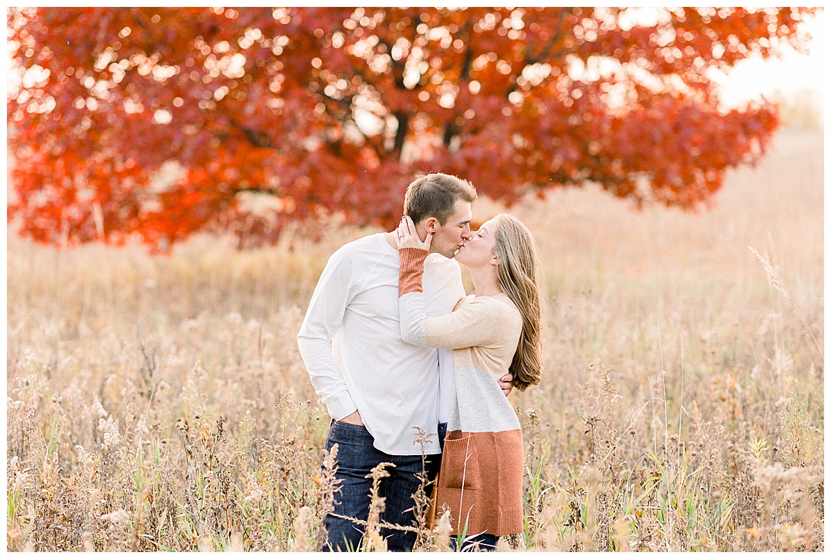 couple kissing near a tree in fall