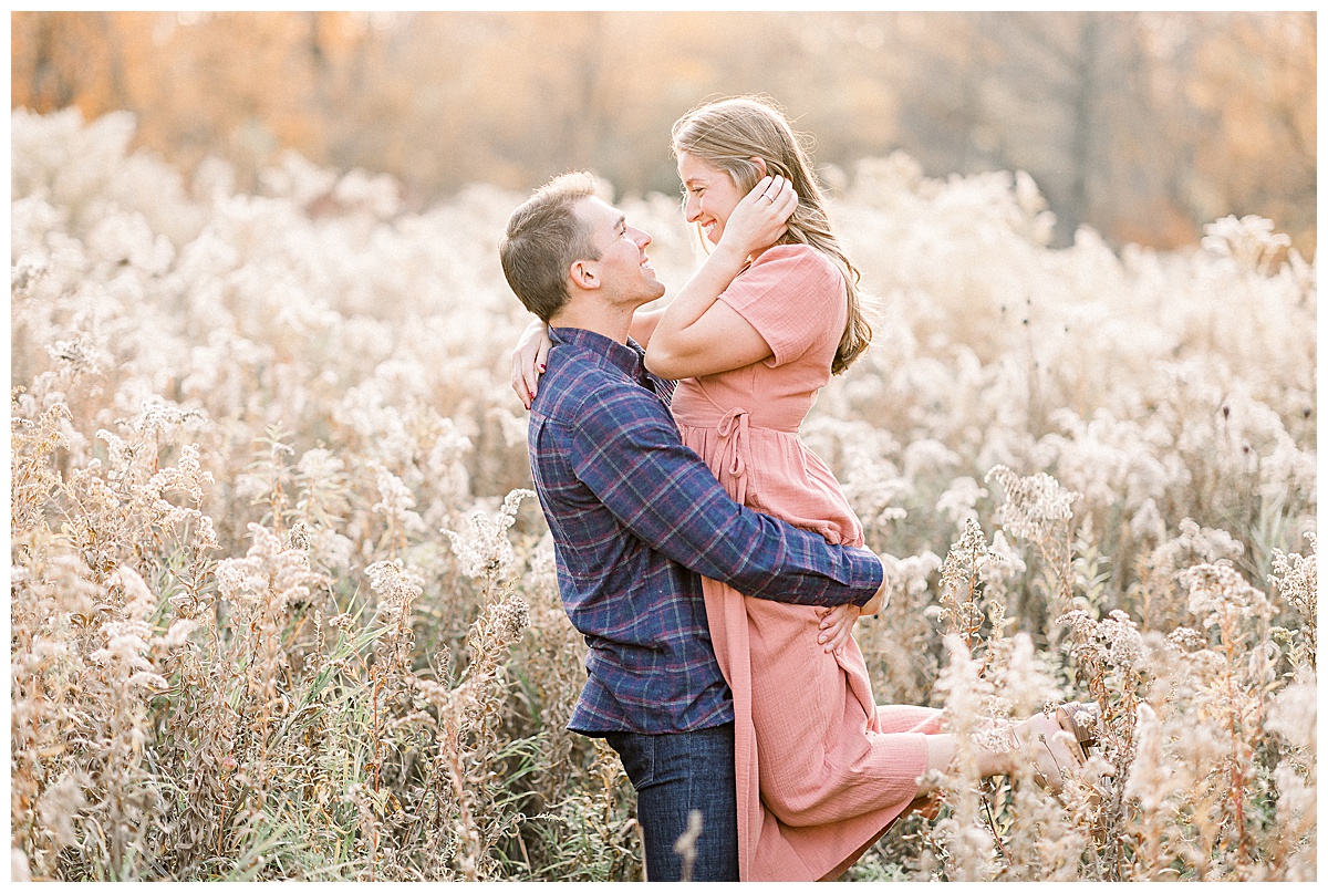 man holding woman for fall engagement photos