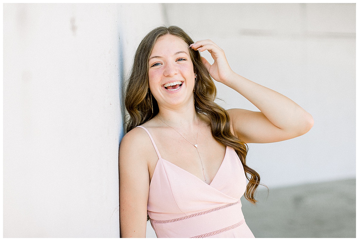 Girl laughing against wall