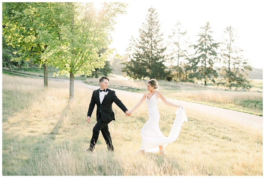 Bride and groom skip through field