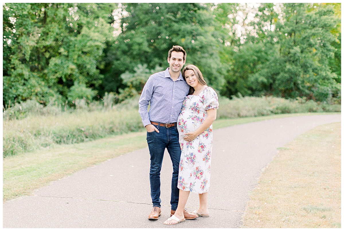 man and woman smiling for maternity session