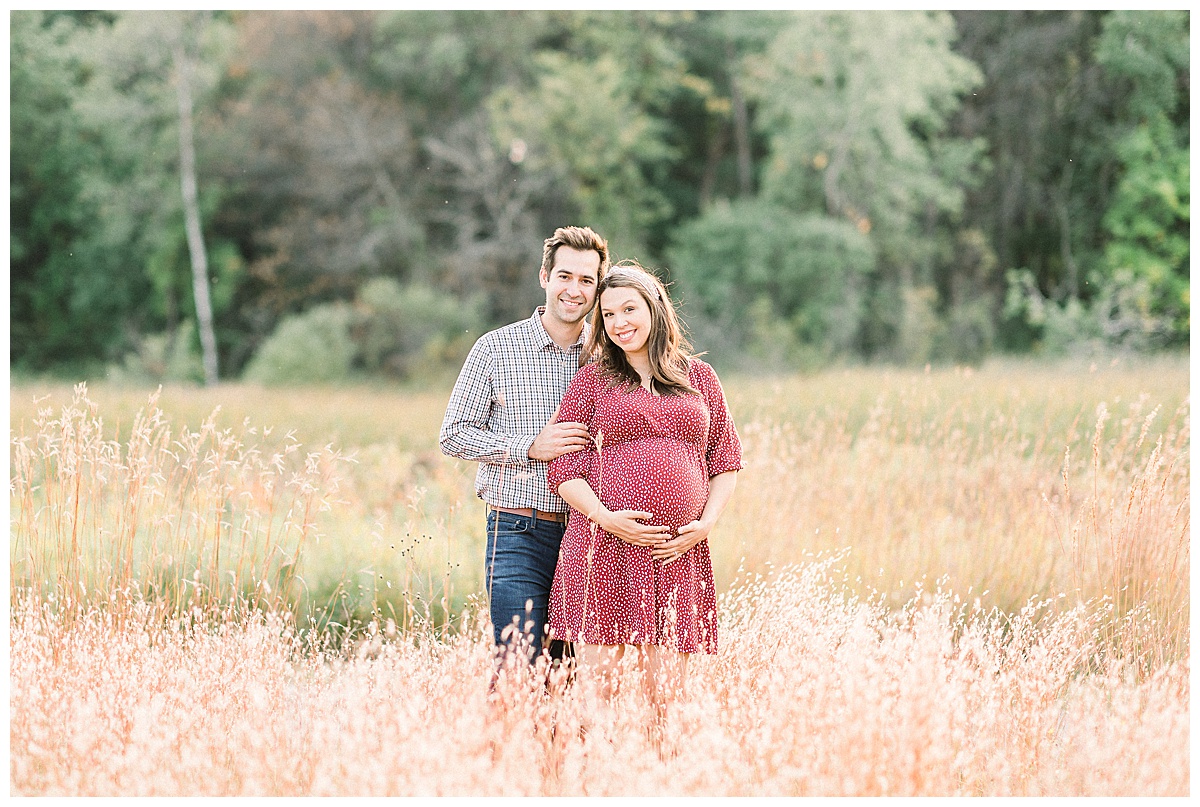 couple smiling for fall maternity session