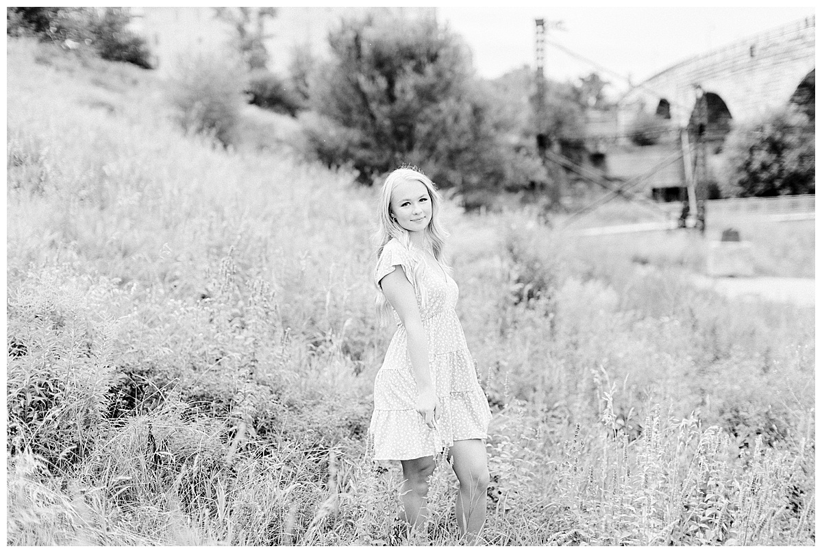girl smiling in field near mill city ruins