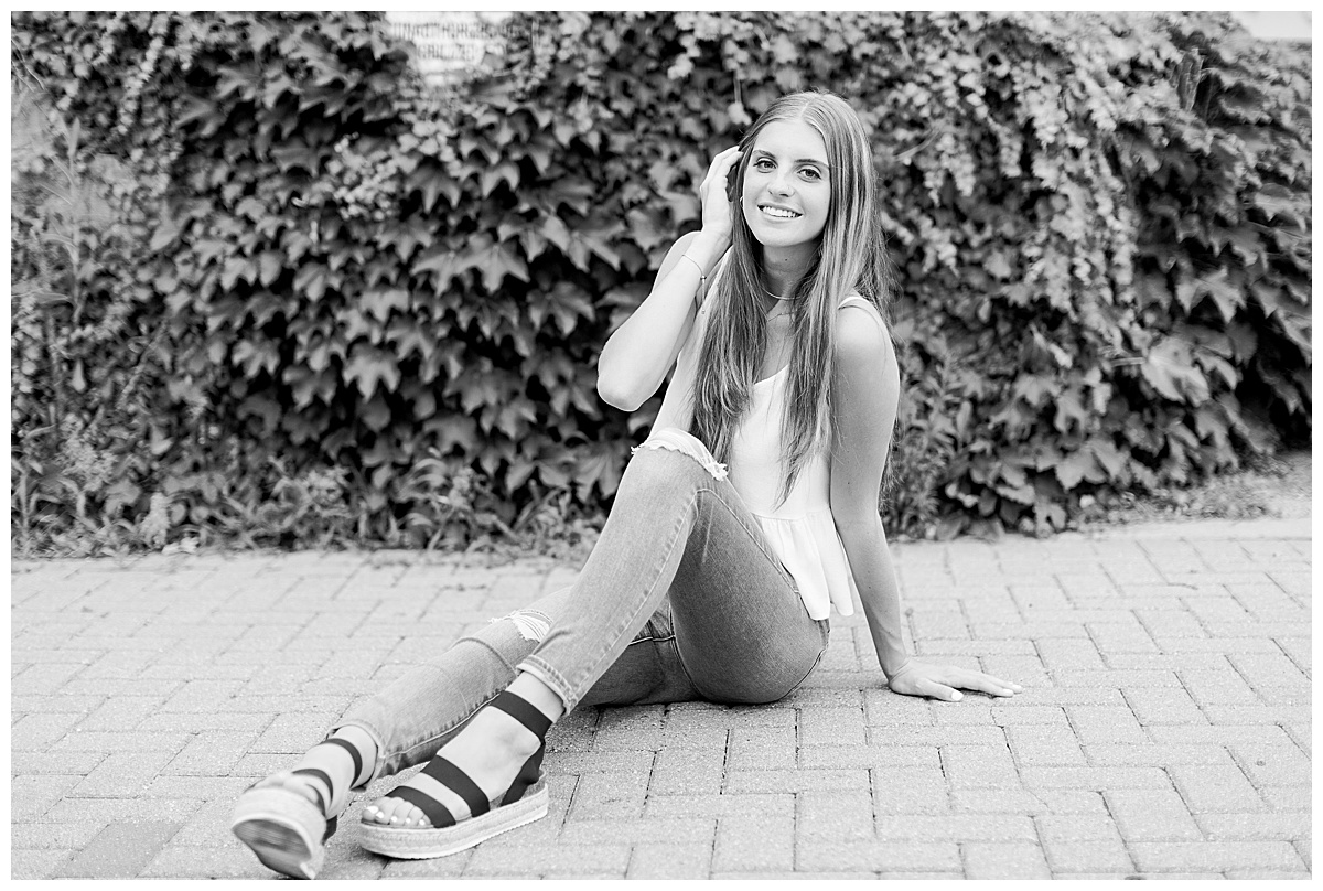 girl sitting on brick path for senior photos