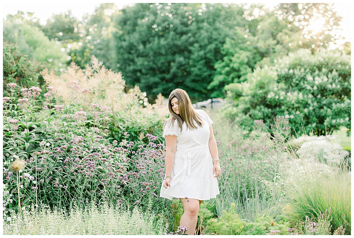 Girl holding dress in field of flowers